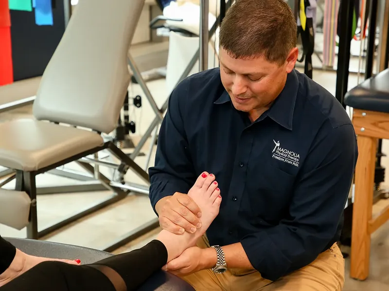 Therapist working on a patient&rsquo;s foot in the clinic gym