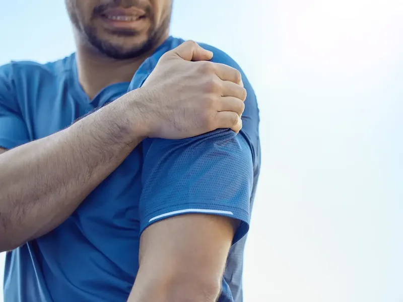 Person holding their shoulder in discomfort