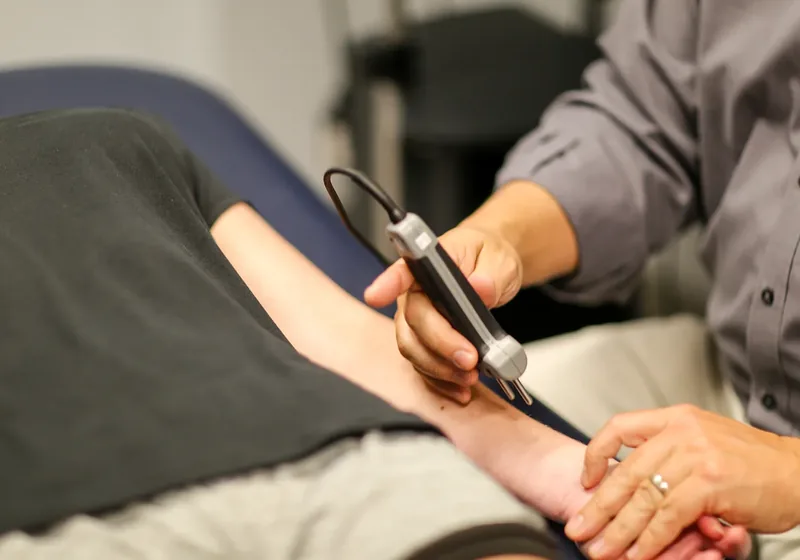 Clinician placing a surface electrode on a patient&rsquo;s lower leg for nerve conduction testing