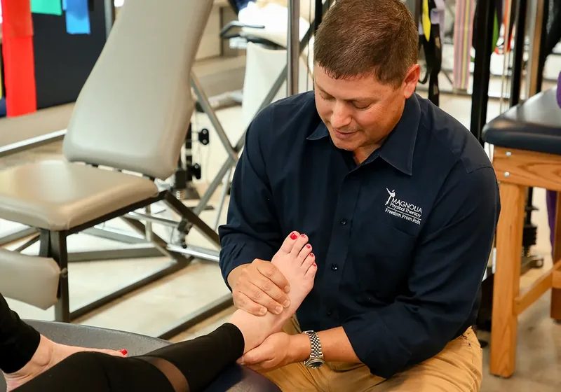 Licensed massage therapist working on a patient's lower leg